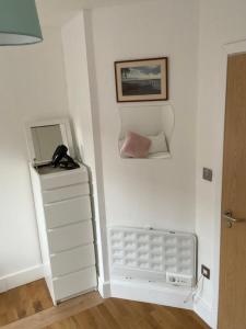 a room with a white wall with a phone on the wall at Lovely Private Rooms in Euston, Central London in London