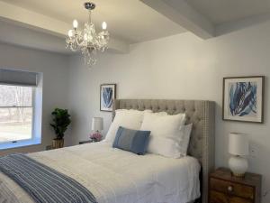 a bedroom with a large bed with a chandelier at Colonial Chic - 3BR home, VA wine country near Harpers Ferry in Purcellville