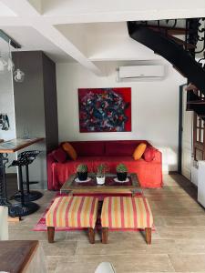 sala de estar con sofá rojo y mesa en Complejo Laguna Chica en Dique Luján