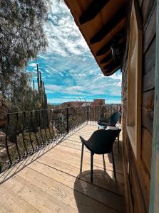 a balcony with two chairs and a view of the desert at Hotel de Piedra in Bernal