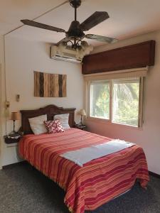 1 dormitorio con 1 cama y ventilador de techo en Complejo Laguna Chica en Dique Luján