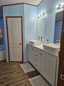 een badkamer met 2 wastafels en een spiegel bij Camp Joy Lake House, Caldwell, TX sleeps 10 in Caldwell