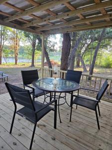 eine Terrasse mit einem Tisch und Stühlen auf einer Terrasse in der Unterkunft Camp Joy Lake House, Caldwell, TX sleeps 10 in Caldwell