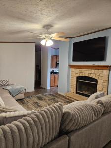 ein Wohnzimmer mit einem Sofa und einem Kamin in der Unterkunft Camp Joy Lake House, Caldwell, TX sleeps 10 in Caldwell