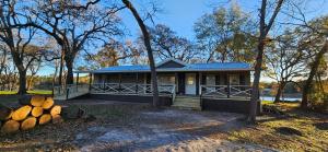 een huis met een hoop houtblokken ervoor bij Camp Joy Lake House, Caldwell, TX sleeps 10 in Caldwell
