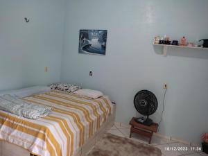 1 dormitorio blanco con 1 cama y ventilador en Linda casa em marudá en Maruda