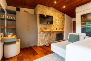 1 dormitorio con pared de piedra en Pousada Boutique Figueira da Serra, en Campos do Jordão