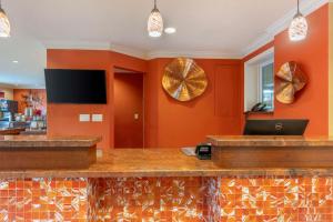 a bar in a restaurant with orange walls at Best Western Plus Airport Plaza in San Jose