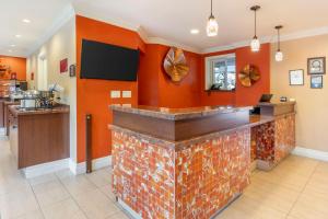 a bar in a restaurant with an orange wall at Best Western Plus Airport Plaza in San Jose
