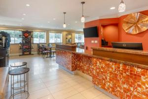 a bar in a restaurant with orange walls at Best Western Plus Airport Plaza in San Jose