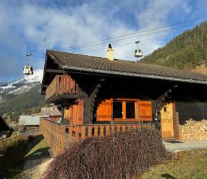 a log cabin with a mountain in the background at Charming, cosy chalet nestled in a breathtaking surrounding with spectacular, stunning mountain views in La Chapelle-dʼAbondance