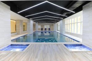 ein Schwimmbad in einem Gebäude mit blauen Fliesen in der Unterkunft TIME Ruba Hotel & Suites in Mekka