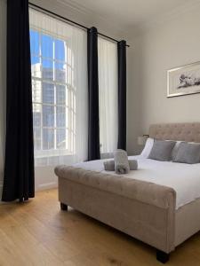 una camera con un grande letto e una grande finestra di Grand Apartment on HOE/BARBICAN Allocated PARKING! a Plymouth