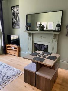 ein Wohnzimmer mit einem Tisch und einem Spiegel in der Unterkunft Grand Apartment on HOE/BARBICAN Allocated PARKING! in Plymouth