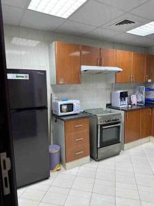 a kitchen with stainless steel appliances and wooden cabinets at Amazing Beachfront Holiday Home in Ajman 