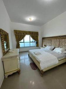 a bedroom with a large bed and a mirror at Amazing Beachfront Holiday Home in Ajman 
