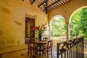 a dining room with a table and chairs on a balcony at Spectacular Hacienda Henequenera with Cenote 