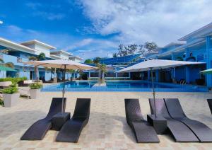una piscina con sedie e ombrelloni accanto a un edificio di Funtasea Hotel and Beach Resort a Iba