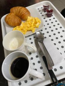 bandeja con un plato de huevos y una taza de café en Hostel Bogotá Kings en Bogotá