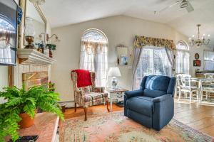 a living room with a blue chair and a fireplace at Glen Cottage with Deck and River View 3 Mi to Skiing! in Glen