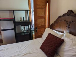 1 dormitorio con 1 cama con cabecero de madera y espejo en The Oliver House en Bisbee