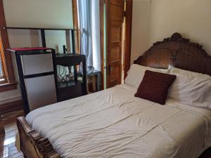 a bed with a wooden headboard and a pillow on it at The Oliver House in Bisbee