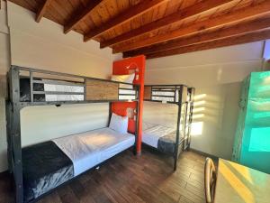 2 Etagenbetten in einem Zimmer mit einem Tisch in der Unterkunft Paris Hostel in Tijuana