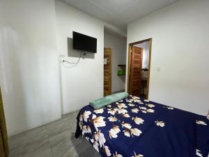 a bedroom with a bed with a blue blanket with flowers at Monte Líbano Suites in Puerto López