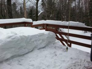 a pile of snow next to a wooden fence at The Last Run - 4BR Chalet between Mt. Snow & Stratton in Wardsboro