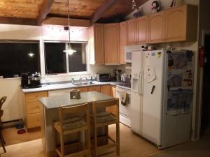 a kitchen with a white refrigerator and a table with chairs at The Last Run - 4BR Chalet between Mt. Snow & Stratton in Wardsboro