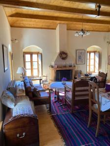 a living room with couches and a table and a fireplace at Παραδοσιακή Κατοικία στο Μαίναλο in Alonistaina +22 photos