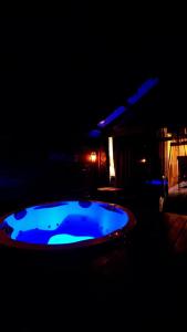 a blue hot tub in a dark room at Chalét-Casa e Bangalo- Villa-Jacuzzi-Sauna-Lareira-Privativo in Campos do Jordão