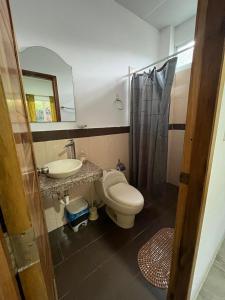 a bathroom with a toilet and a sink and a mirror at Monte Líbano Suites in Puerto López