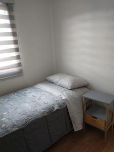 um pequeno quarto com uma cama e uma mesa em Lomas del hualle em Valdivia