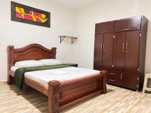 ein Schlafzimmer mit einem Holzbett und einer Kommode in der Unterkunft Refugio en el bosque in Barbosa