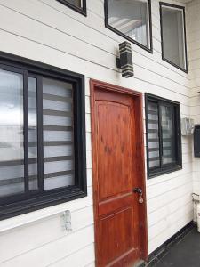 uma porta de madeira ao lado de uma casa em Lomas del hualle em Valdivia