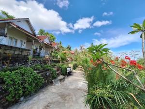 una casa con flores delante en La Colina Bungalow en Nusa Penida