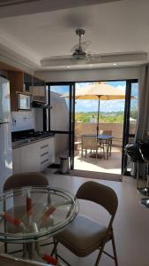 eine Küche mit Glastisch und eine Terrasse in der Unterkunft Guarajuba, Camaçari, Bahia, 2 quartos com suíte, cobertura, terraço in Camassari