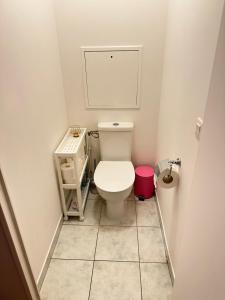 a small bathroom with a toilet and a pink stool at Jade Apart Bussy Centre Disney 10min in Bussy-Saint-Georges +25 photos