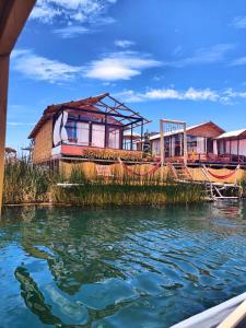 ein Haus am Ufer eines Wasserkörpers in der Unterkunft Uros TITIKAKA the Best lodge in Puno