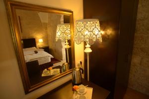 a bedroom with a mirror and a table with a lamp at St. George’s Cathedral Pilgrim Guesthouse – Jerusalem in Jerusalem