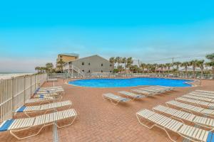 um grupo de espreguiçadeiras e uma piscina em Tidewater Beach Resort em Panama City Beach