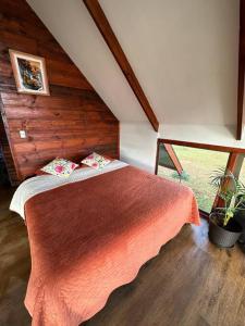 a bedroom with a bed with a red blanket at Terevaka Lodge in Hanga Roa
