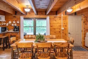 uma sala de jantar com uma grande mesa de madeira e cadeiras em Creekside Hideaway em Reedsville