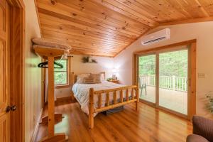 a bedroom with a bed and a balcony at Creekside Hideaway in Reedsville