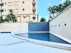 a swimming pool in front of a building at Vista Panorâmica Enseada in Guarujá