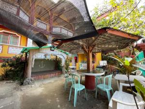 eine Außenterrasse mit Tischen, Stühlen und einer Bühne in der Unterkunft Manalo's Lodge and Restaurant in Puerto Galera