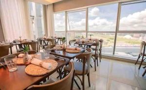 a restaurant with tables and chairs and large windows at Hotel Vision in Brasilia