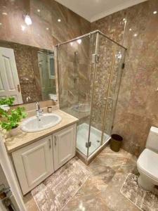 uma casa de banho com um chuveiro, um lavatório e um WC. em Elegant Villa in Sheikh Zayed City, Egypt - Families Only em Sheikh Zayed