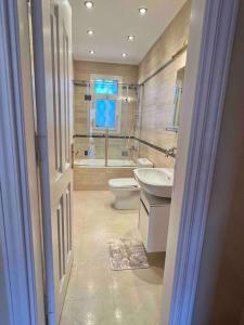 y baño con aseo, lavabo y ducha. en Elegant Villa in Sheikh Zayed City, Egypt - Families Only en Sheikh Zayed